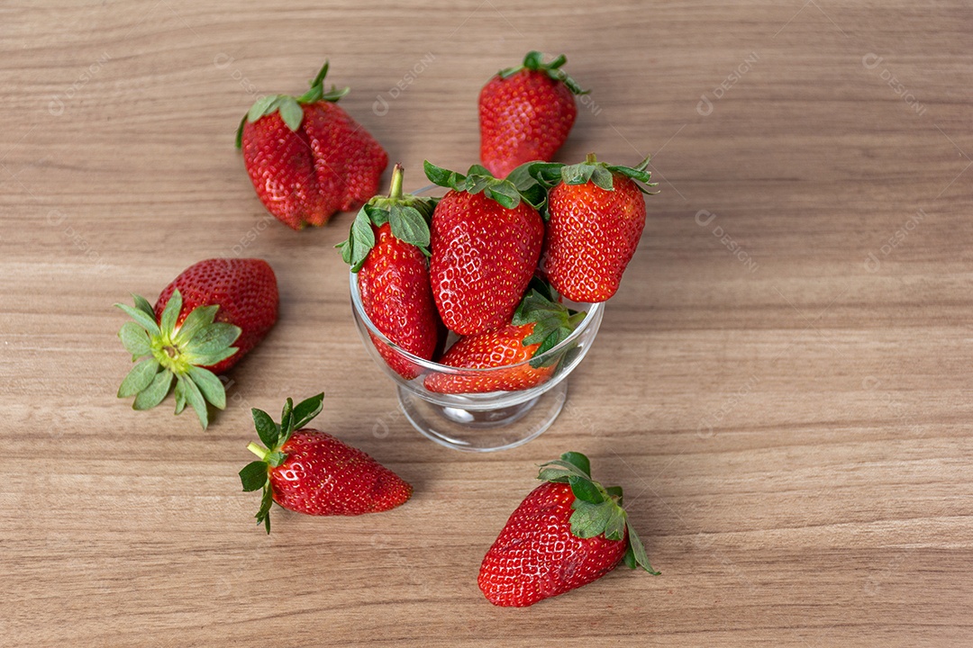 tigela de morangos em fundo de madeira.