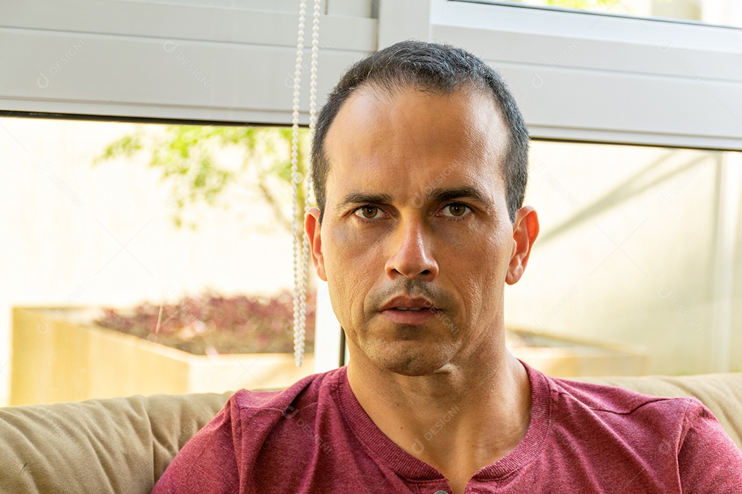 Detalhe de um homem de meia idade sentado no sofá, com os braços