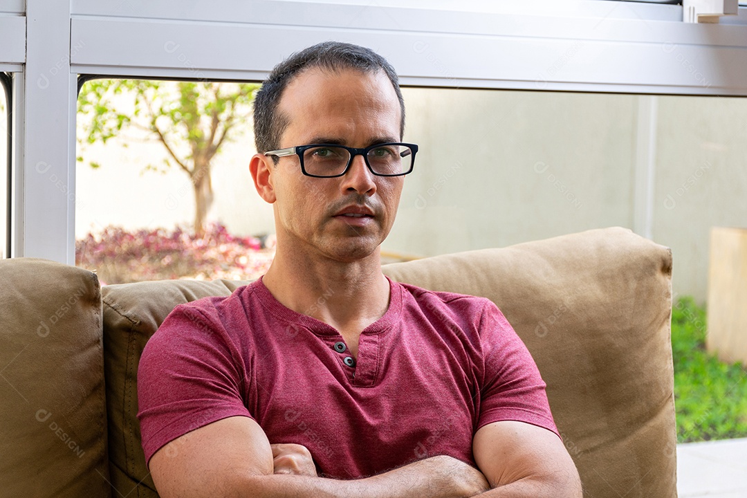 Closeup de um homem de meia idade com óculos, com os braços cruzados