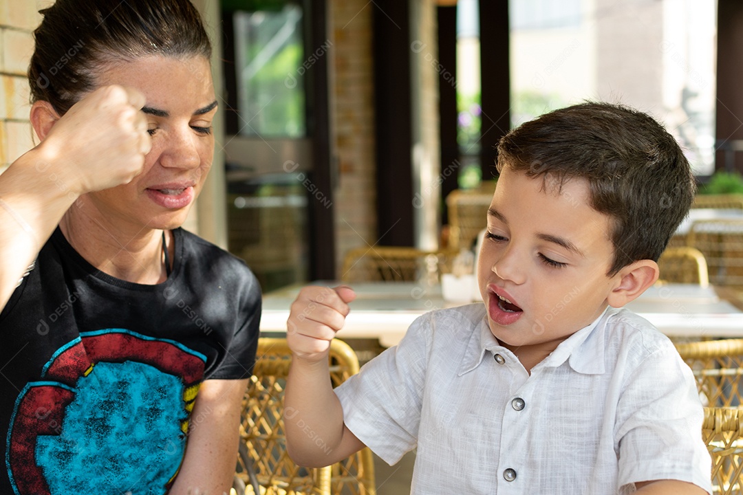 Mãe e filho fazendo saudação com soco.