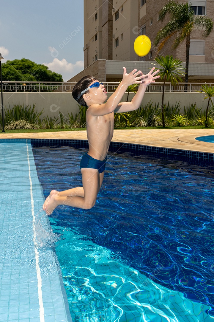 Menino de 6 anos brincando com balão dágua em piscina.