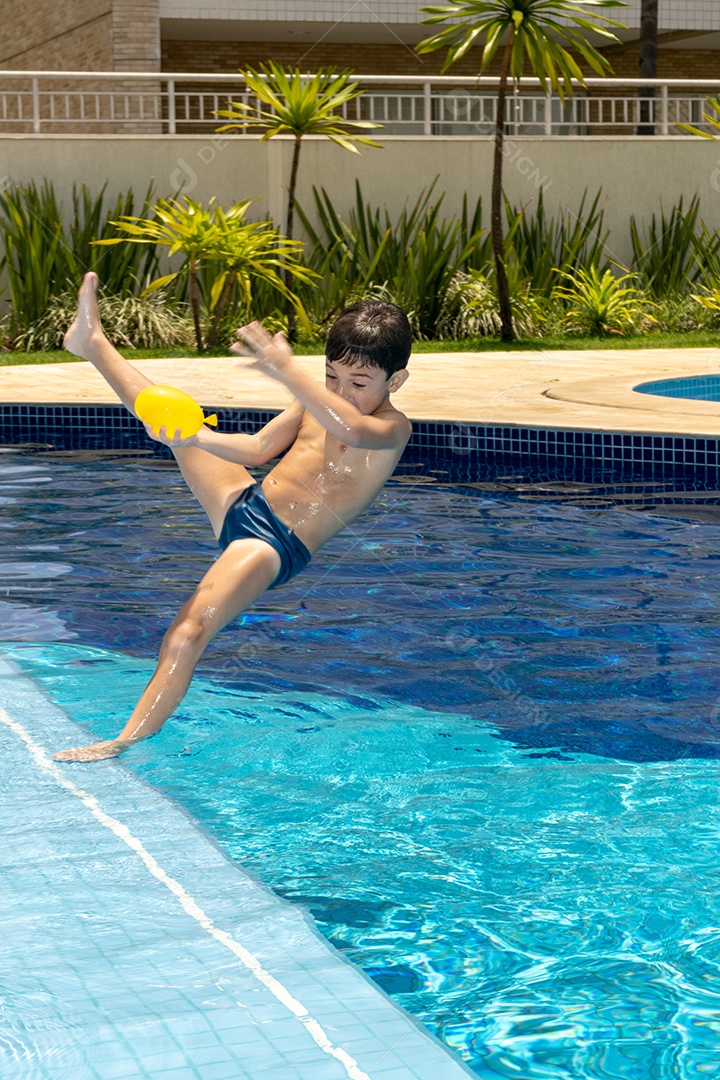 Menino de 6 anos brincando com balão dágua em piscina.