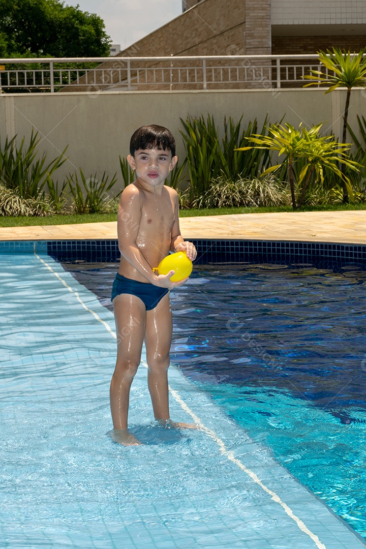 Menino de 6 anos se preparando para brincar com balão dágua.