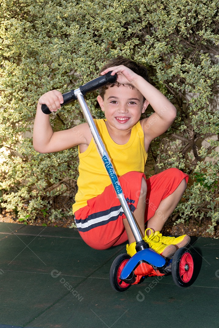 Menino de 6 anos brincando com sua scooter.