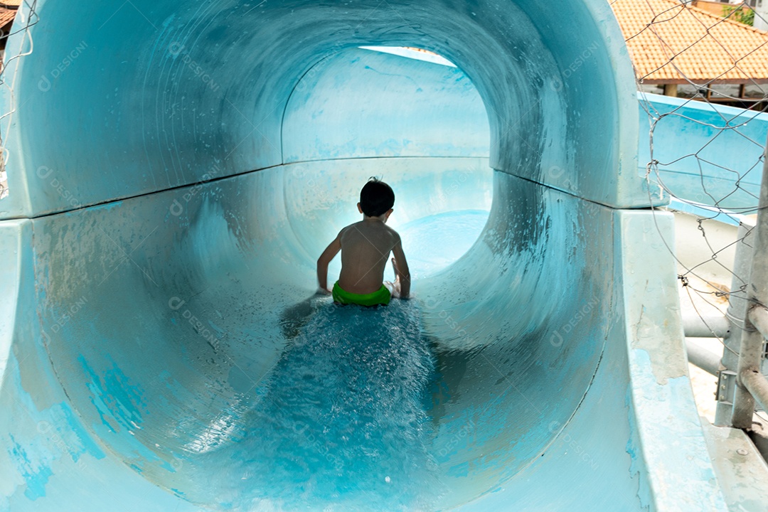 Menino descendo de tobogã.