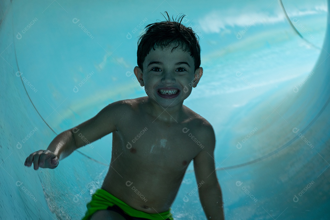 Menino descendo de tobogã.