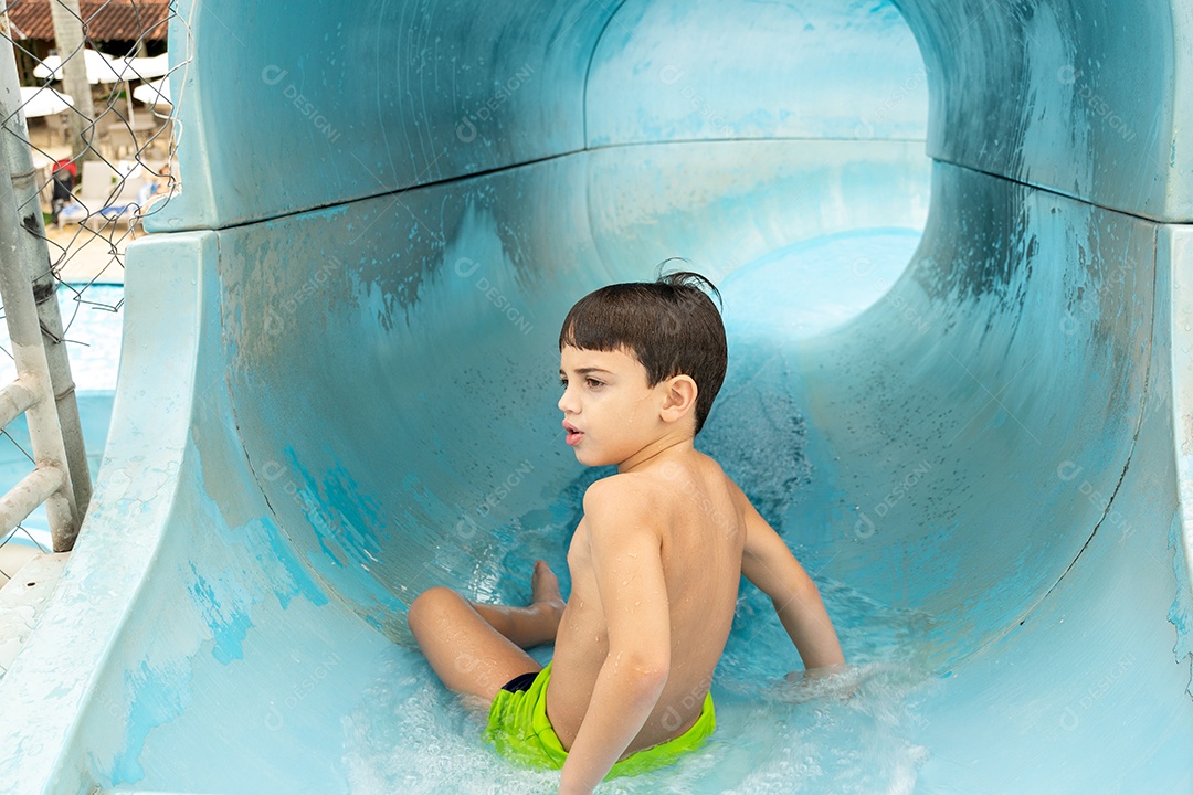 Menino pronto para descer no tobogã.