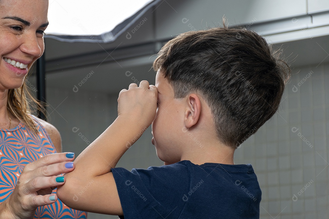 Mãe e filho fazendo biscoitos de Natal e interagindo em sua própria cozinha.