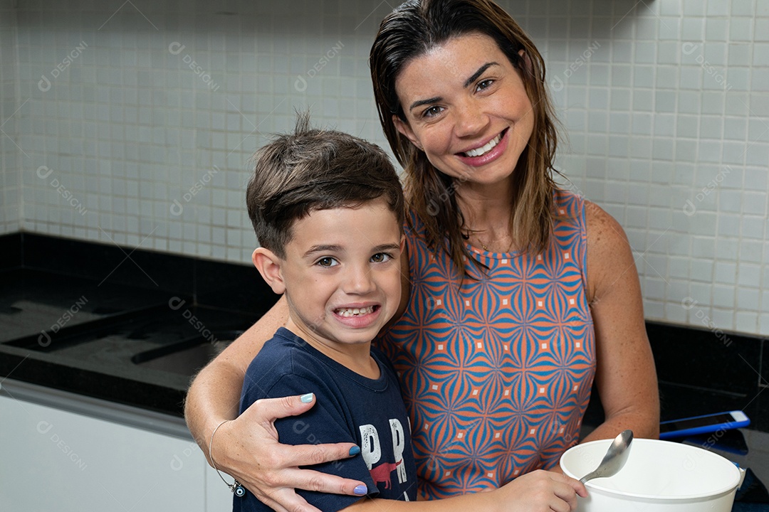 Mãe e filho fazendo biscoitos de Natal e interagindo em sua própria cozinha.