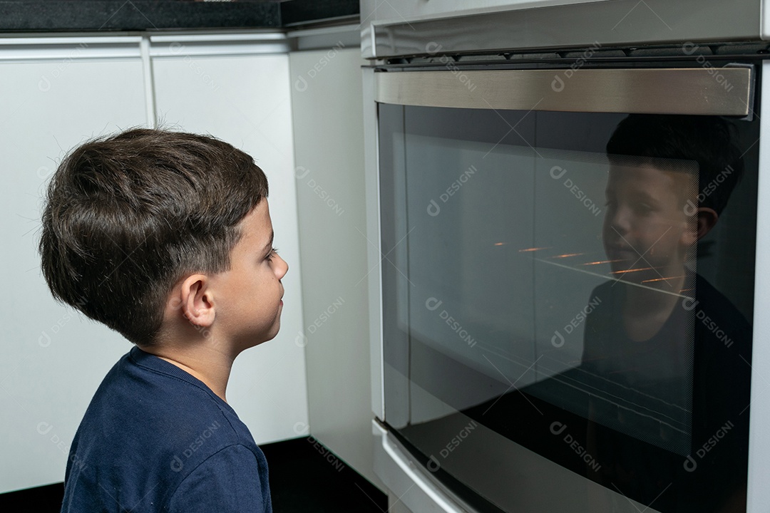Garoto ajudando a mãe a fazer biscoitos e lambendo o dedo.