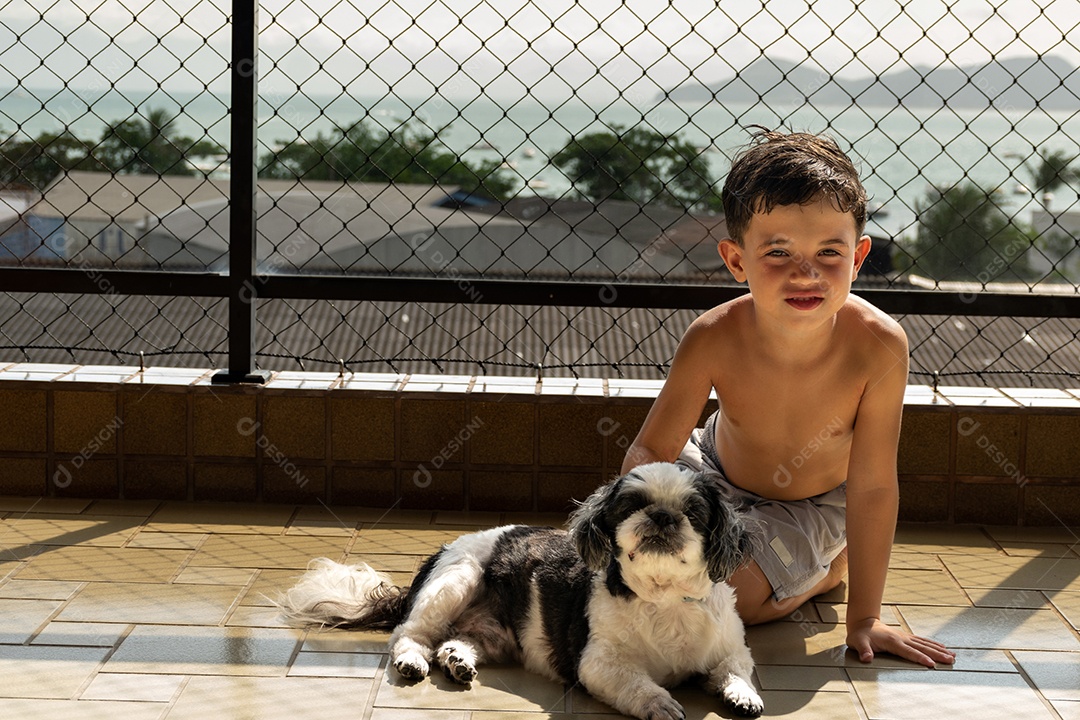 Menino posando ao lado de seu cachorro Shih Tzu