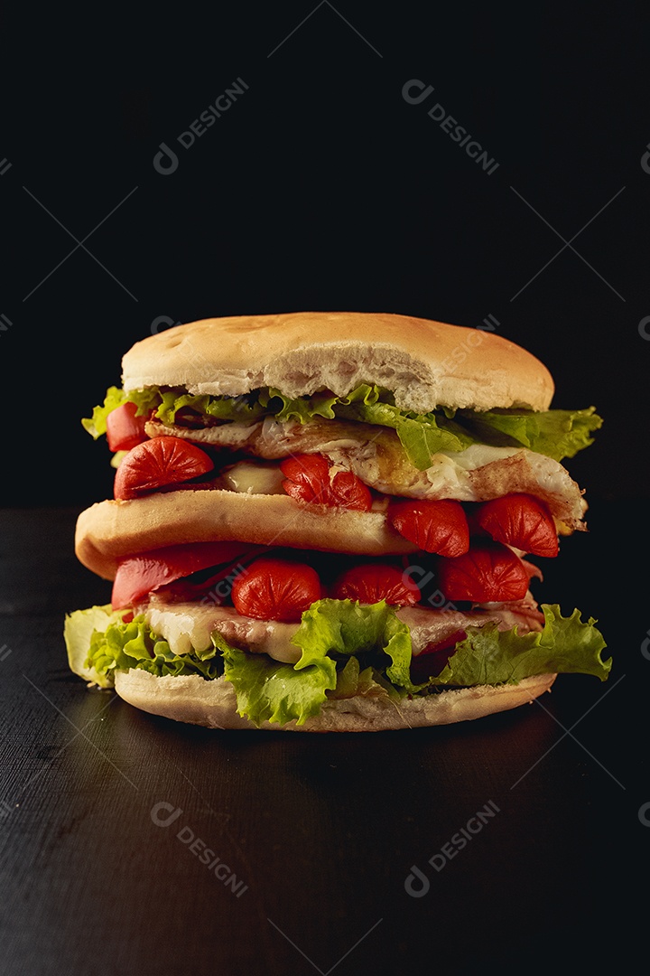 Sanduiche sobre fundo preto salsicha alface carne