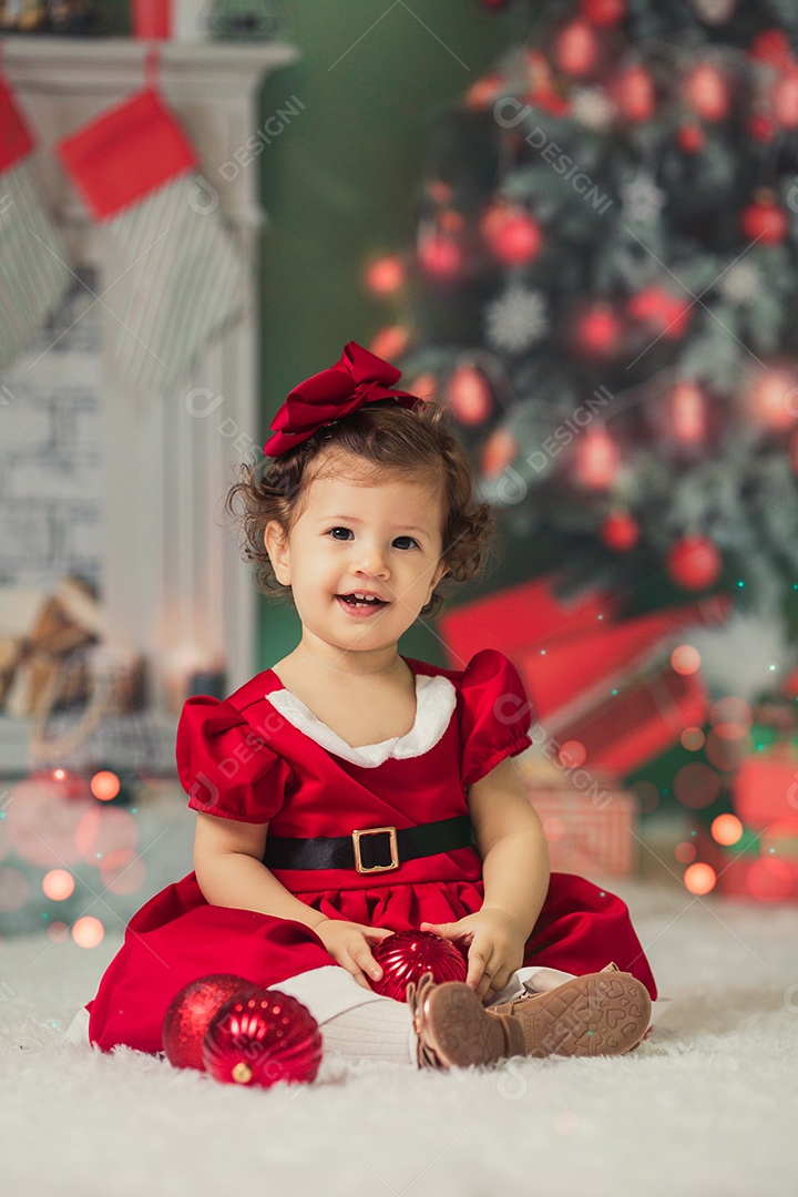 Linda menina fantasiada de Papai Noel sobre um linda casa decorada de Natal