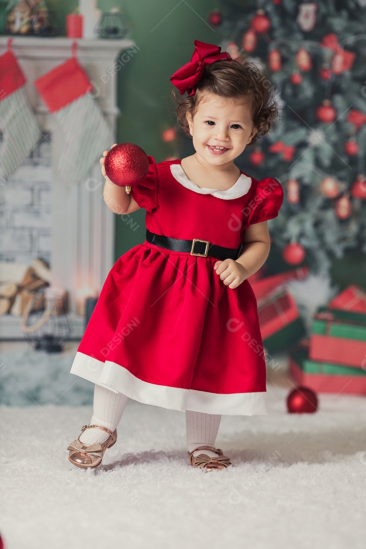Linda menina fantasiada de Papai Noel sobre um linda casa decorada de Natal