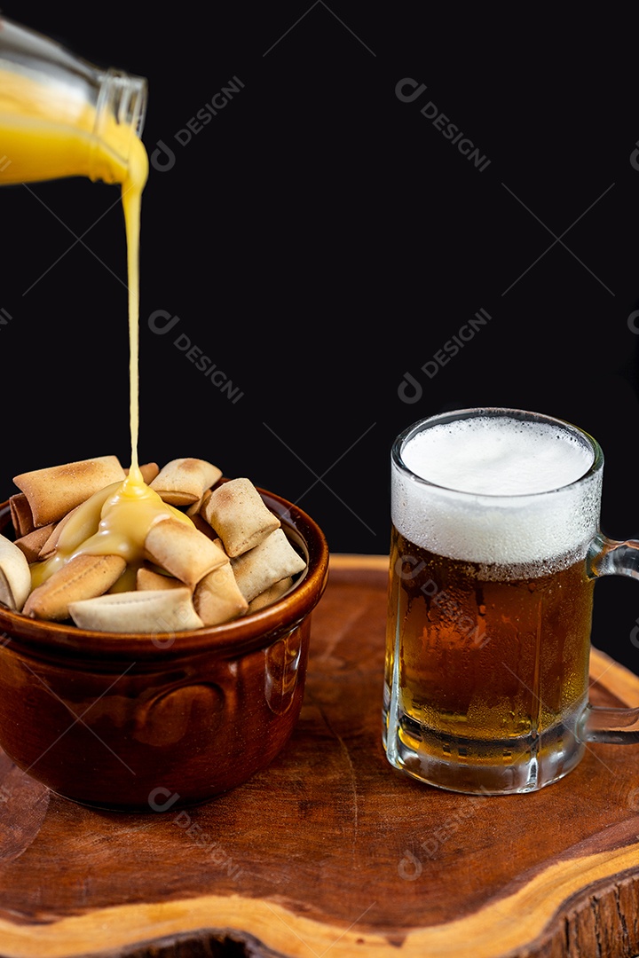 Biscoitos sobre uma tigela ao lado de caneca de cerveja tabua de madeira