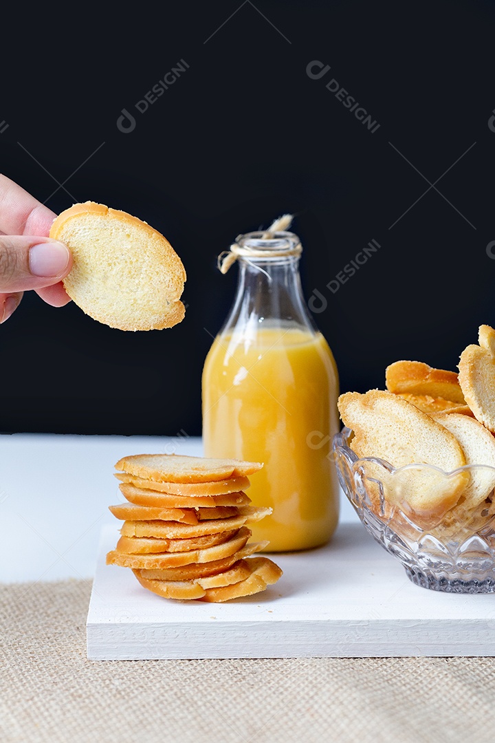 Pães sobre uma tigela ao lado de jarra de suco tabua de madeira