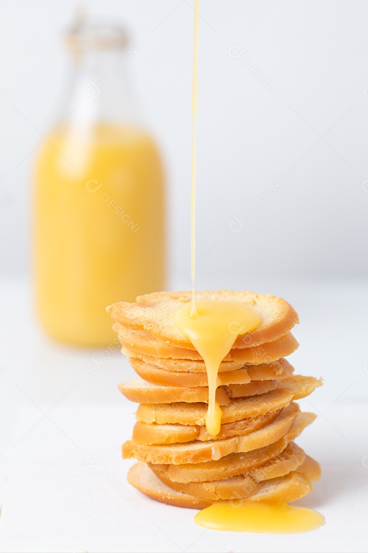 Pães sobre uma tigela ao lado de jarra de suco tabua de madeira
