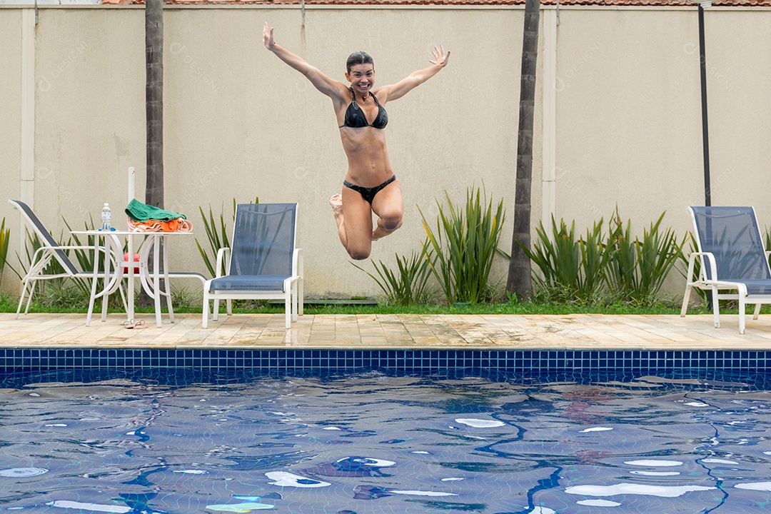 Mulher e filho em sessão de fotos correndo e pulando na piscina.