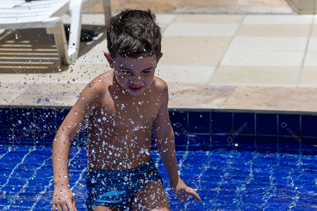 Menino jovem garoto criança brincando sobre beira piscina