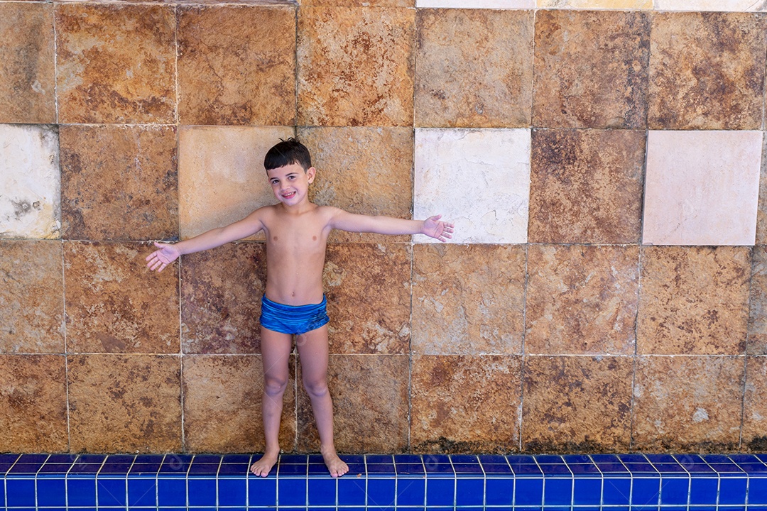 Menino jovem garoto criança brincando sobre beira piscina