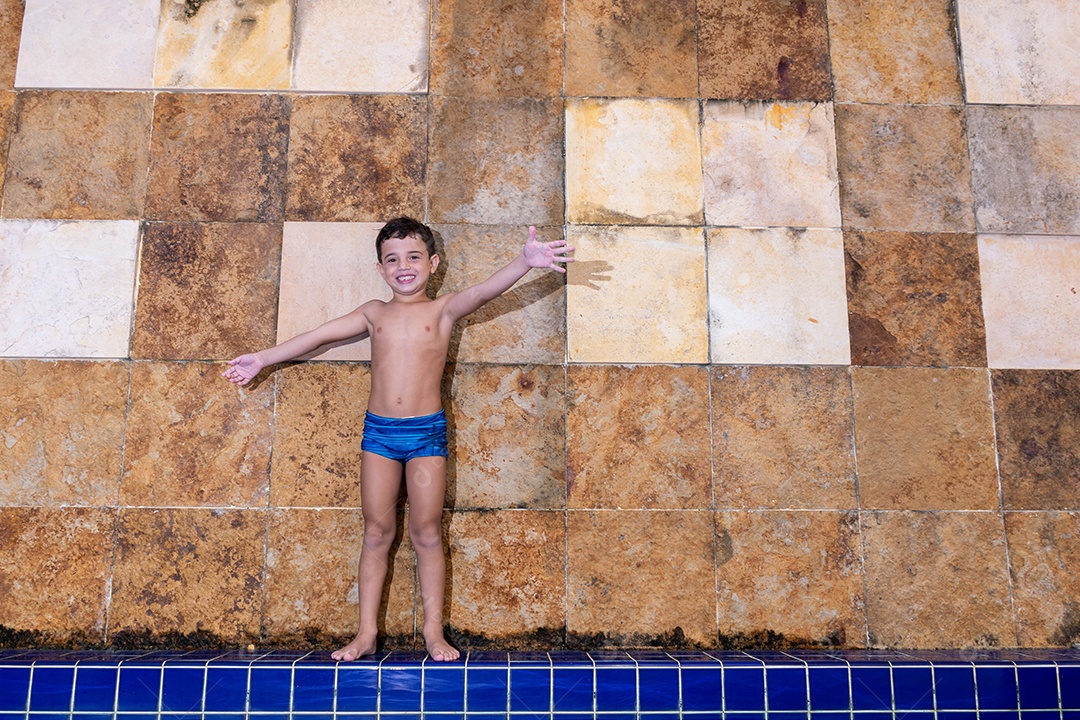 Menino jovem garoto criança brincando sobre beira piscina