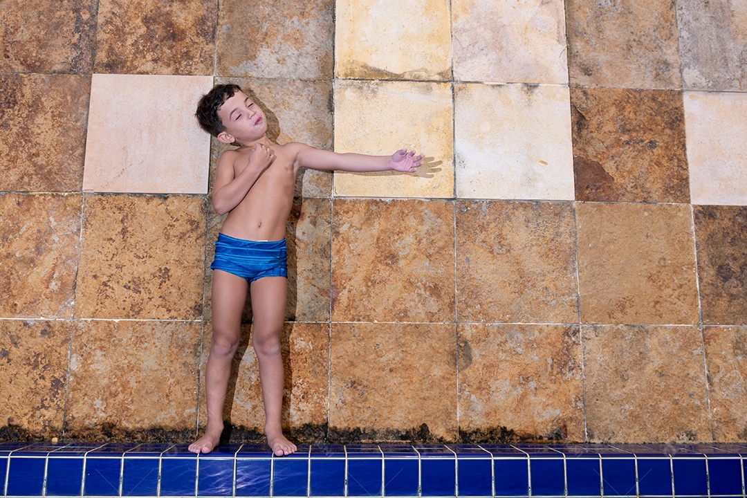 Menino jovem garoto criança brincando sobre beira piscina