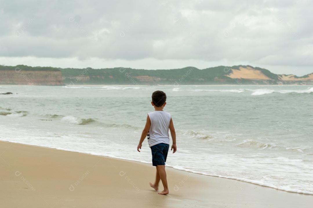 Caminhada pela praia de Pipa com as falésias da Baía dos Golfinhos ao fundo.
