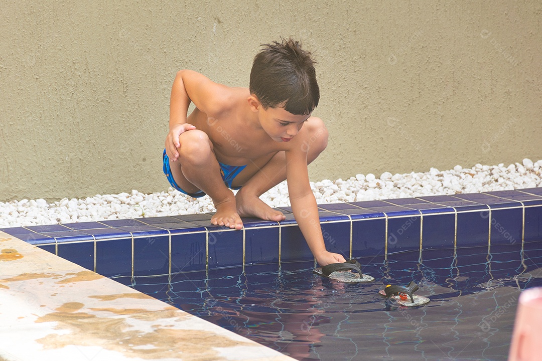 Menino jovem garoto criança brincando sobre beira piscina