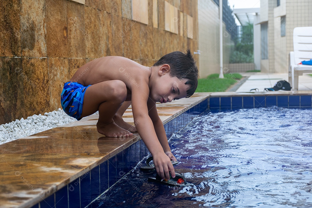Menino jovem garoto criança brincando sobre beira piscina