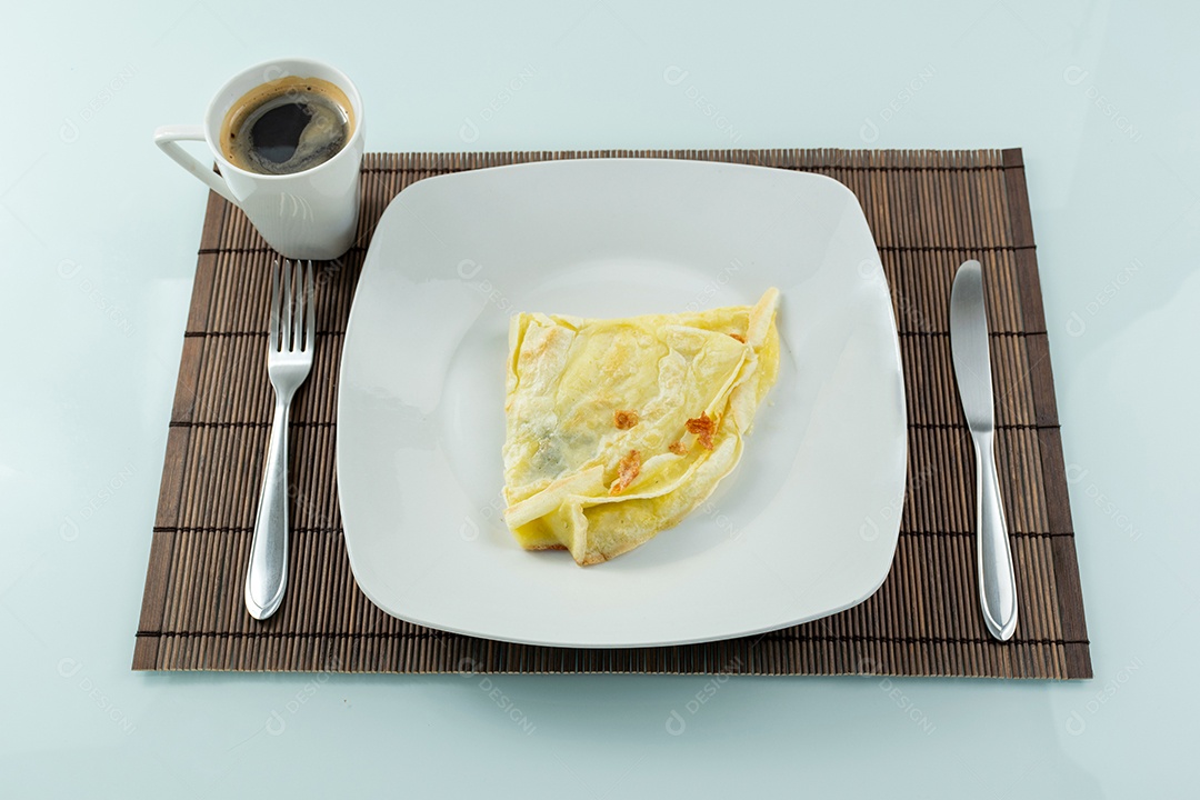 Crepioca com recheio de queijo ao lado de garfo e faca brasileiro