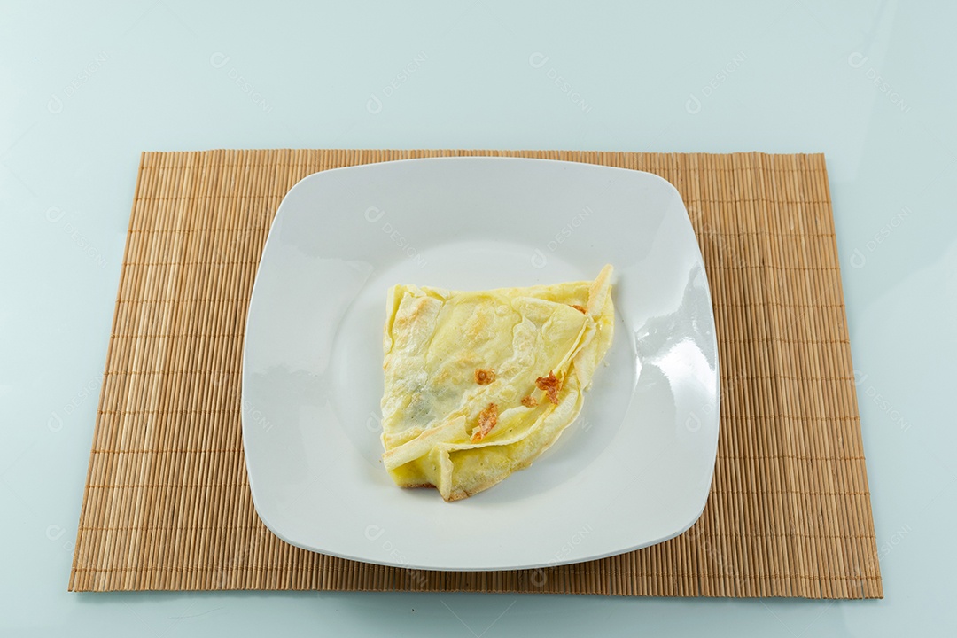 Crepioca com recheio de queijo ao lado de garfo e faca brasileiro