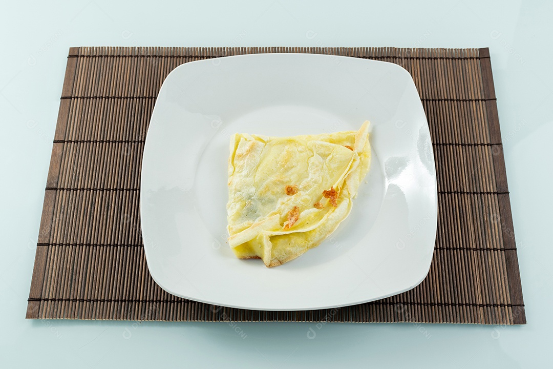 Crepioca com recheio de queijo ao lado de garfo e faca brasileiro