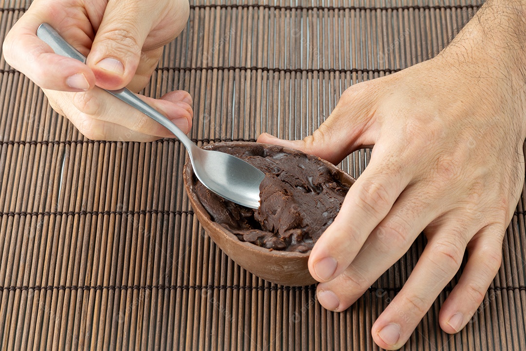 Adult's right hand picking up the stuffing from the easter egg com