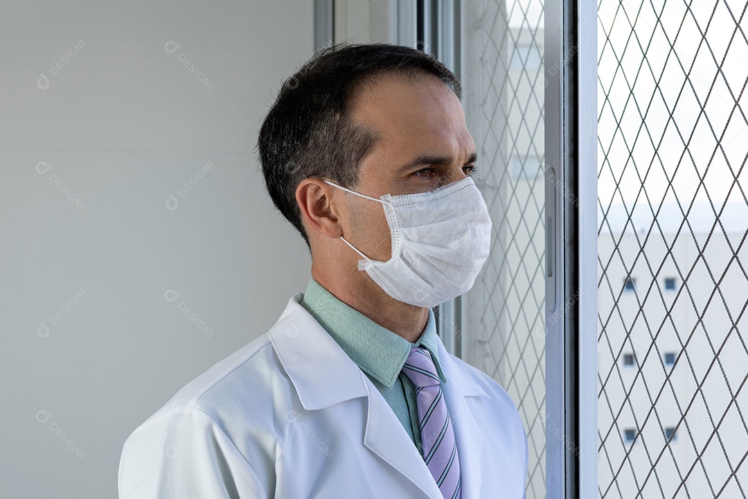 Médico de 44 anos, sorridente, de jaleco branco e gravata