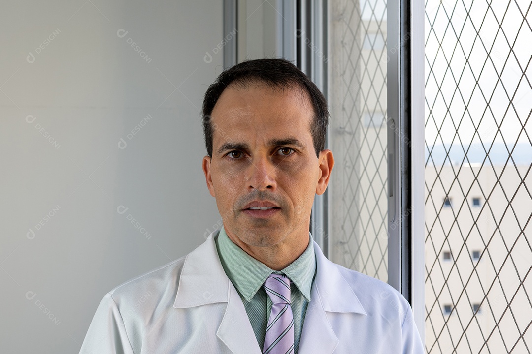 Médico de 44 anos, sorridente, de jaleco branco e gravata