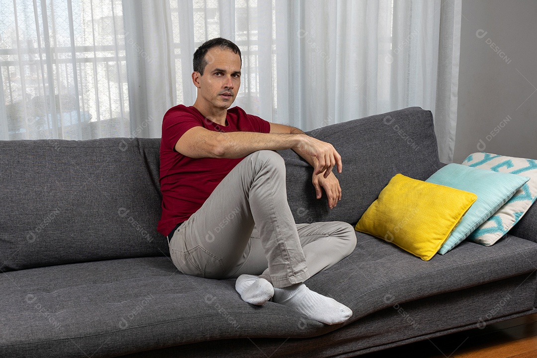 Homem jovem sentando no sofá sobre conforto de sua casa