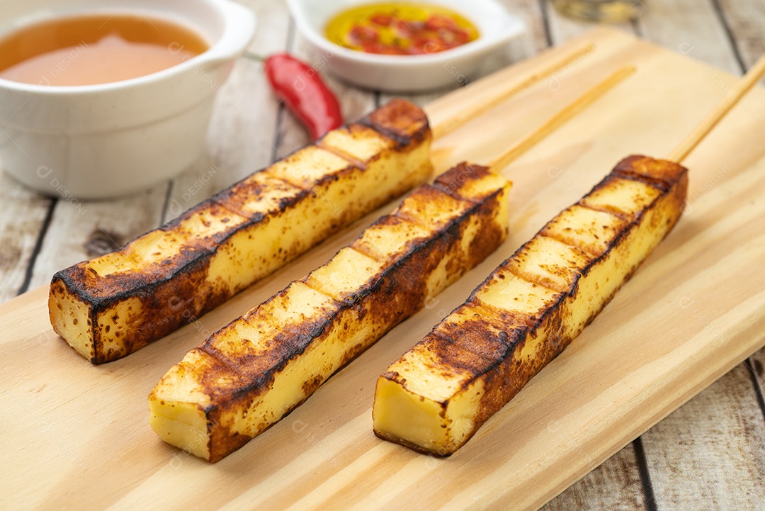 Queijo Coalho ou Coalho grelhado em tábua de madeira com calda de açúcar e pimenta.