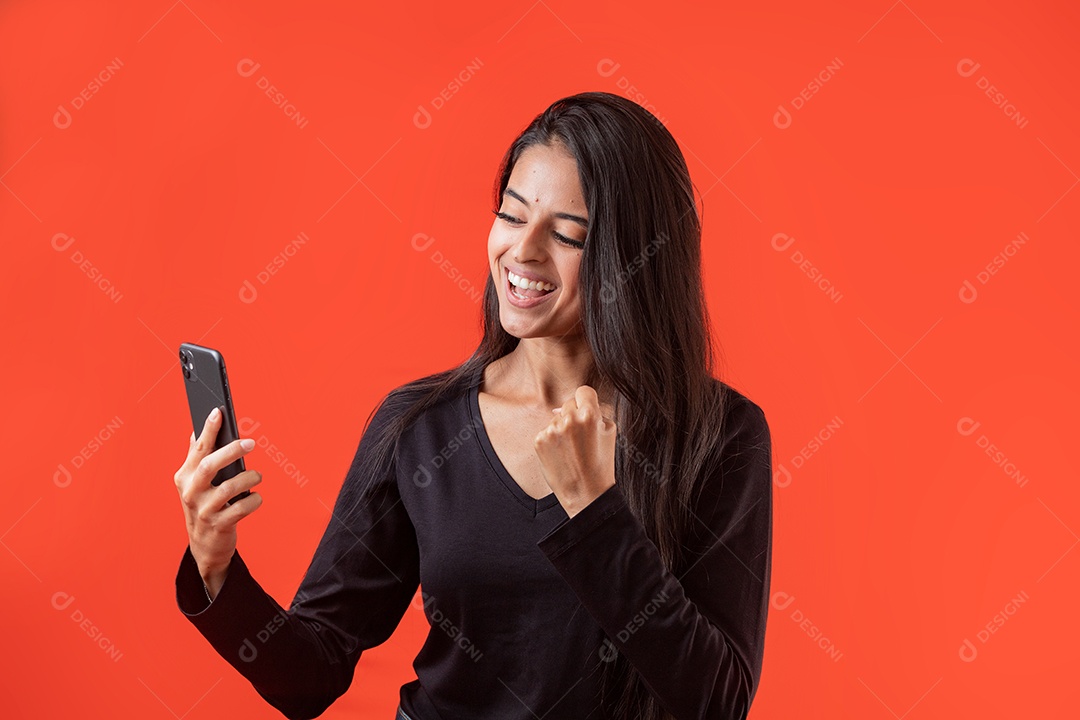 Linda mulher jovem segurando celular sobre fundo vermelho