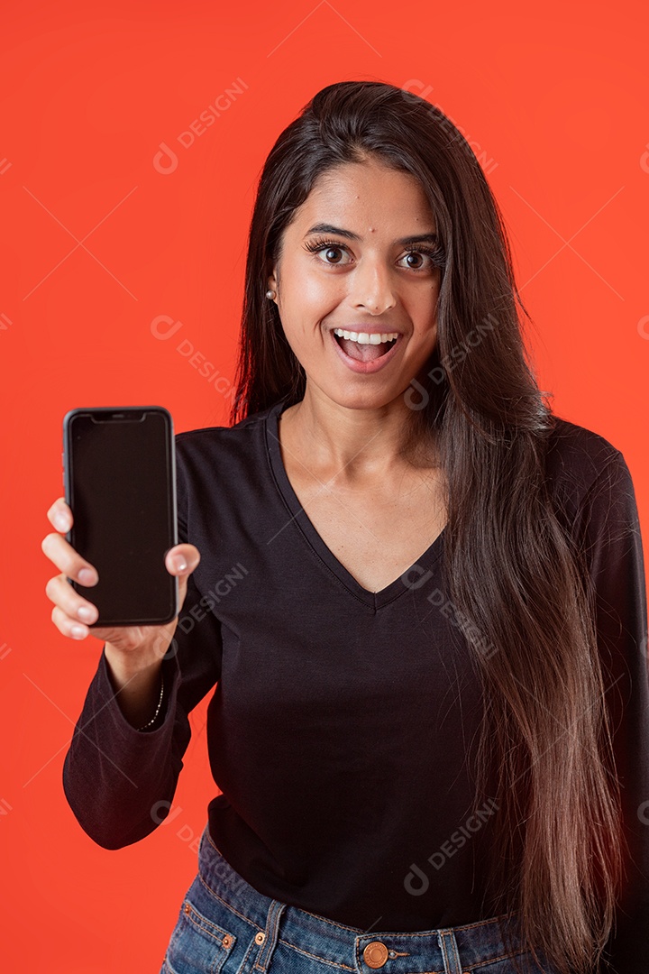 Linda mulher jovem segurando celular sobre fundo vermelho