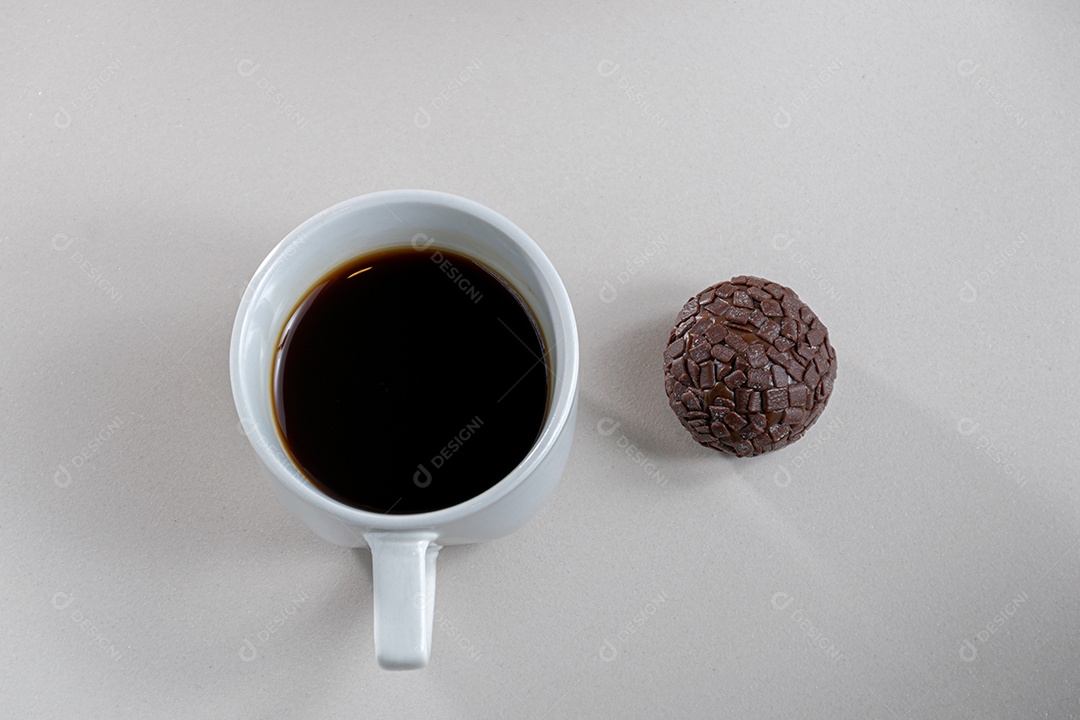 Xícara de café ao lado de um brigadeiro doce tradicional para crianças