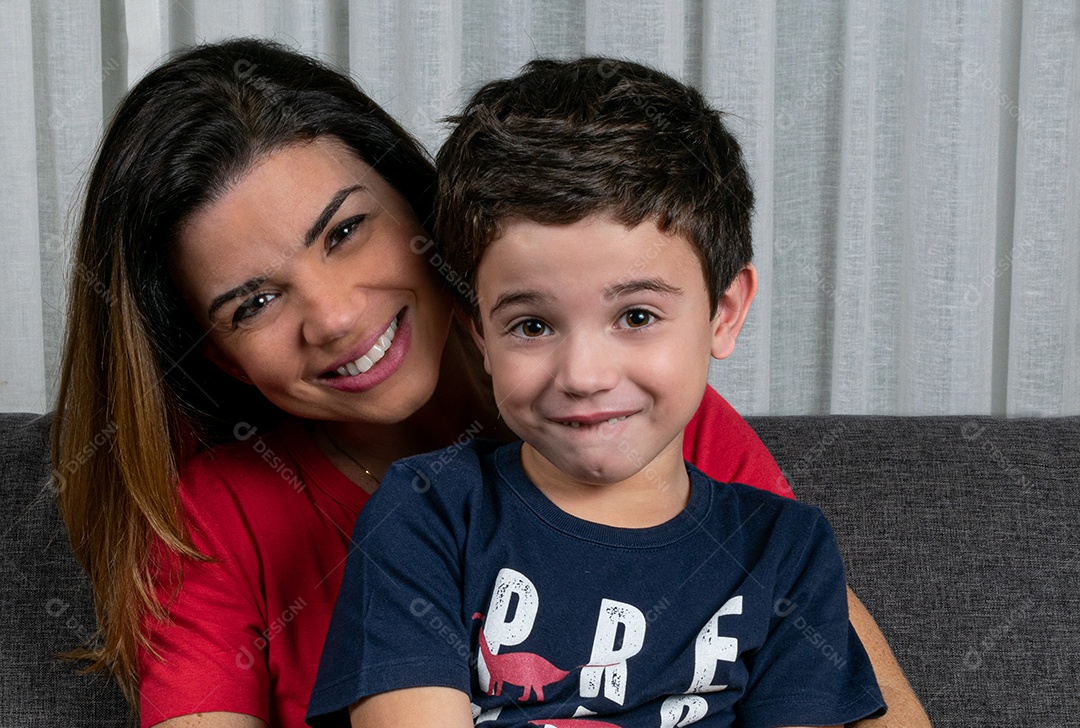 Mulher madura sentada no sofá, interagindo com seu filho, livros e vários papéis adesivos.