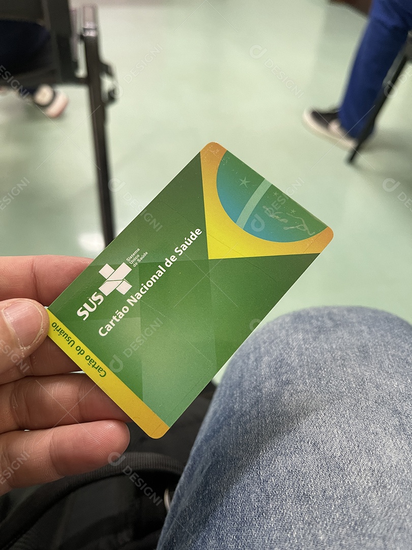 Homem na sala de espera do hospital com o Cartão Único de Saúde (SUS) do Brasil.