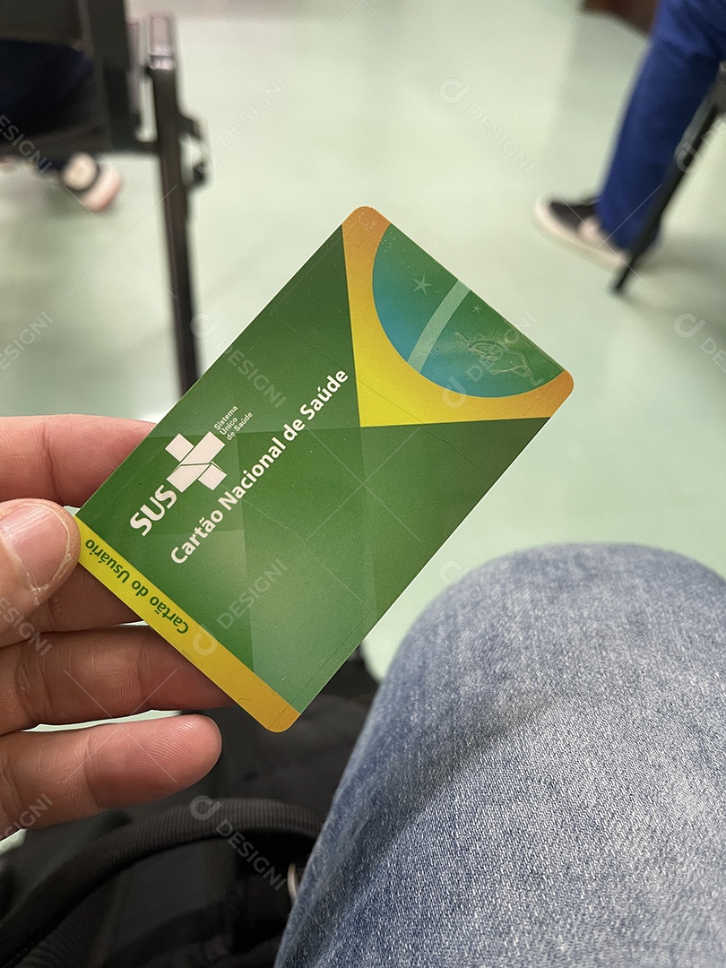 Homem na sala de espera do hospital com o Cartão Único de Saúde (SUS) do Brasil.