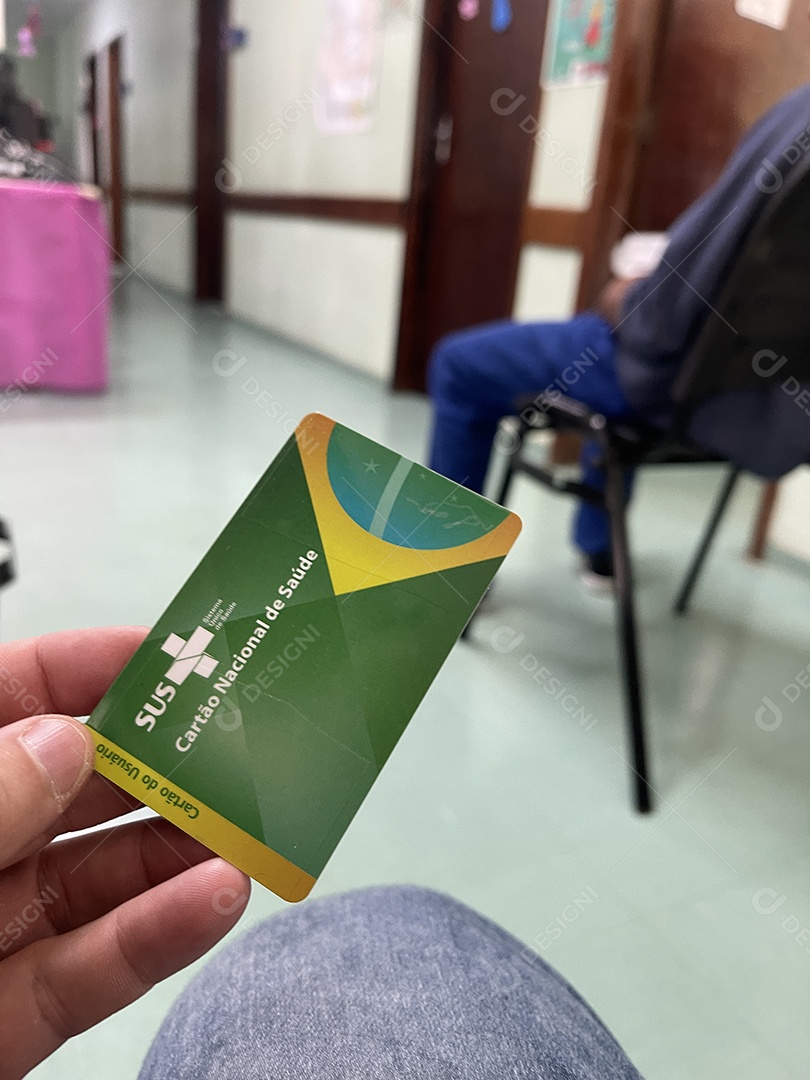 Homem na sala de espera do hospital com o Cartão Único de Saúde (SUS) do Brasil.