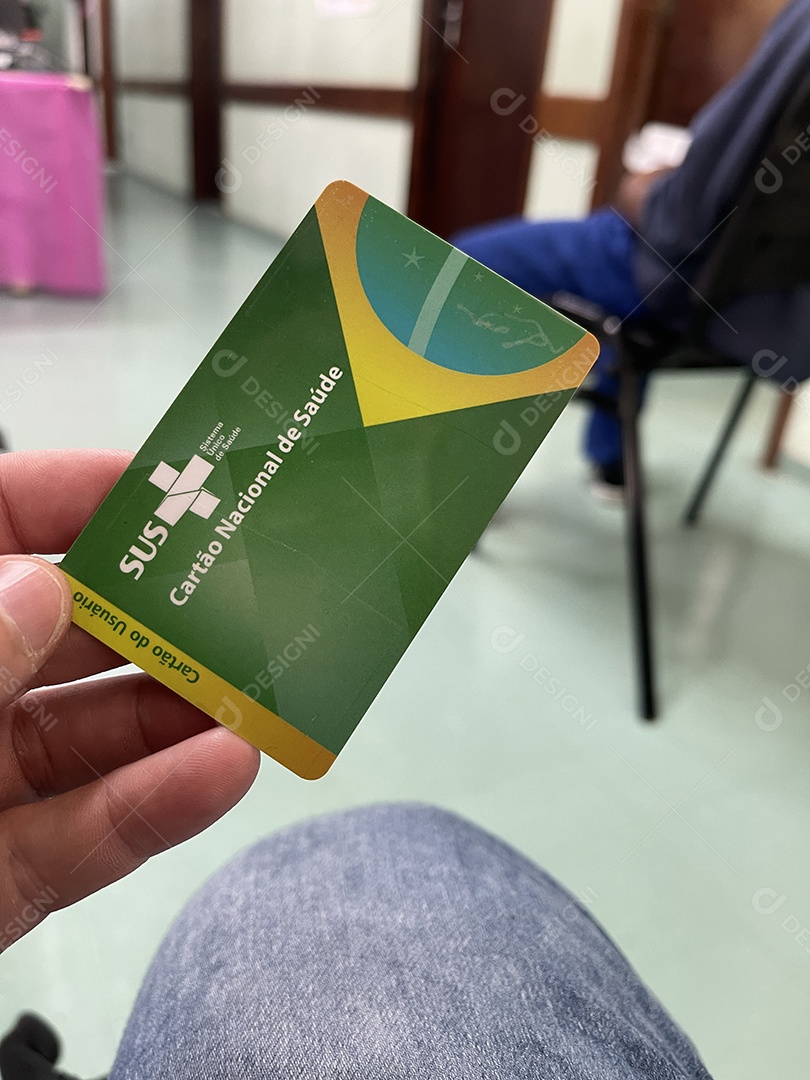 Homem na sala de espera do hospital com o Cartão Único de Saúde (SUS) do Brasil.