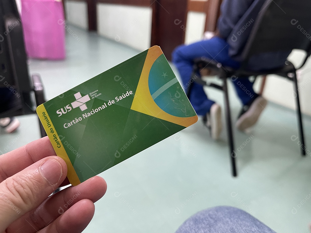 Homem na sala de espera do hospital com o Cartão Único de Saúde (SUS) do Brasil.