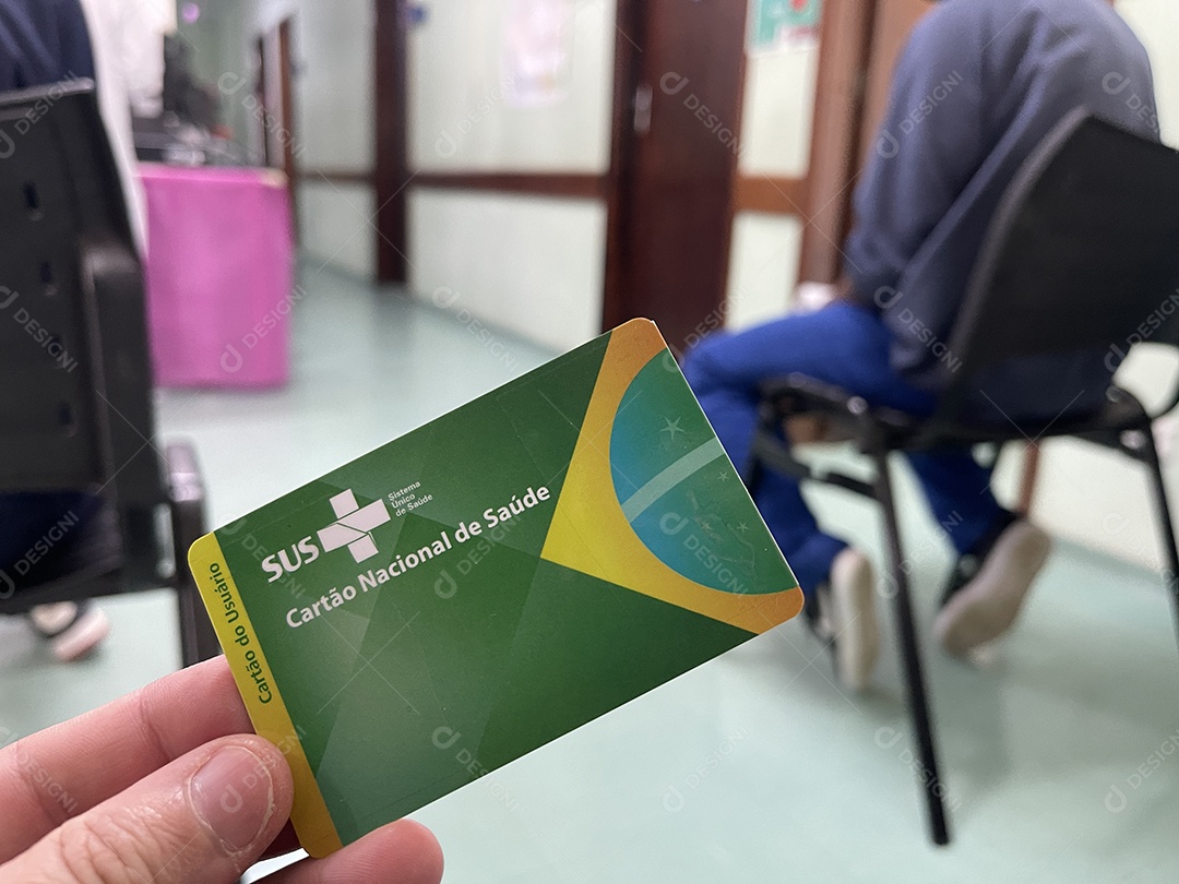 Homem na sala de espera do hospital com o Cartão Único de Saúde (SUS) do Brasil.