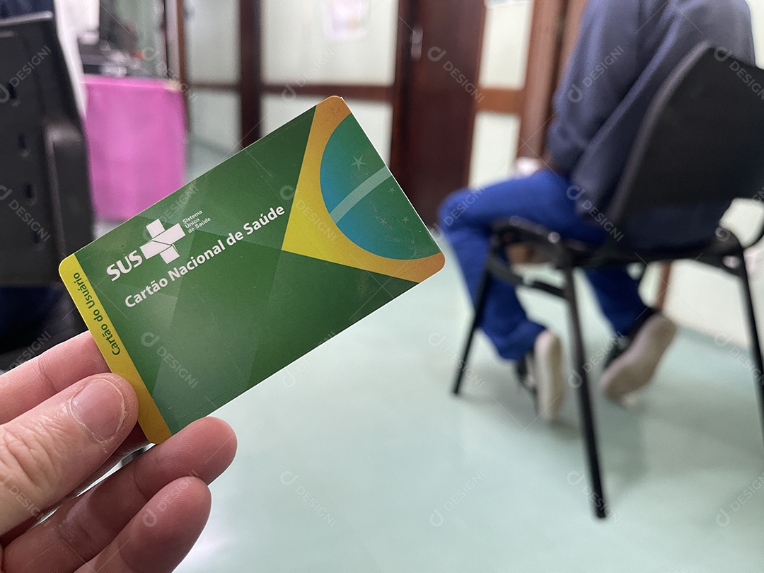 Homem na sala de espera do hospital com o Cartão Único de Saúde (SUS) do Brasil.