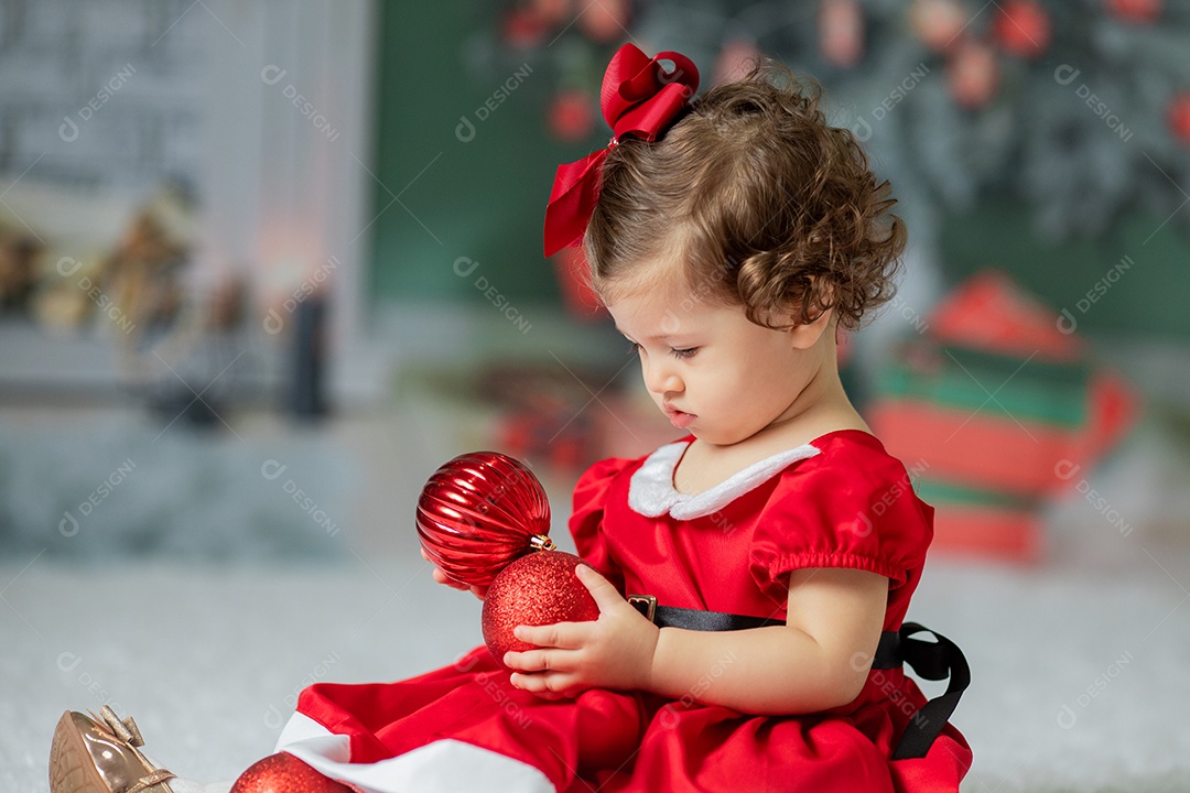 Linda menina fantasiada de Papai Noel sobre um linda casa decorada de Natal