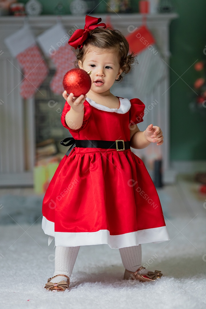 Linda menina fantasiada de Papai Noel sobre um linda casa decorada de Natal